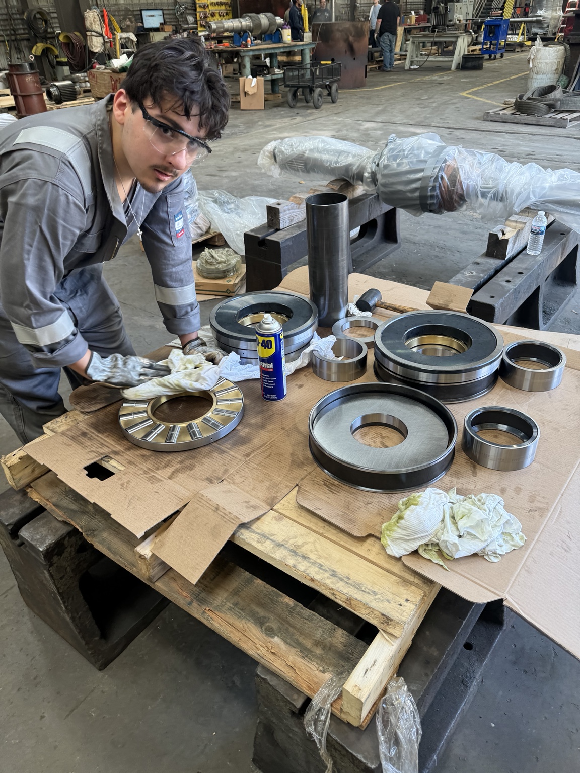 Technician inspecting disassembled rotating equipment bearings and components