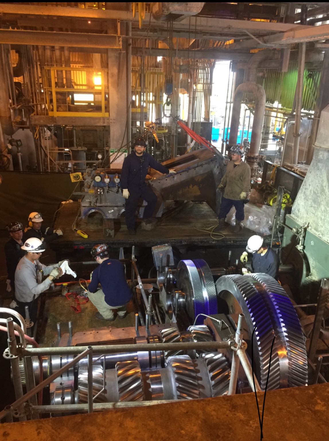 Field crew working around an open industrial gearbox