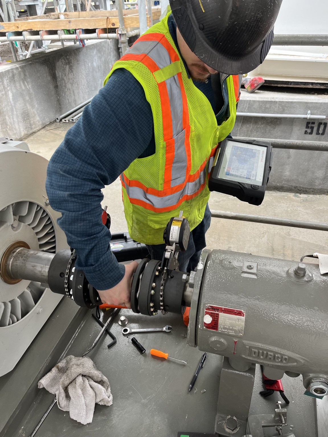 Technician performing laser shaft alignment on industrial rotating equipment